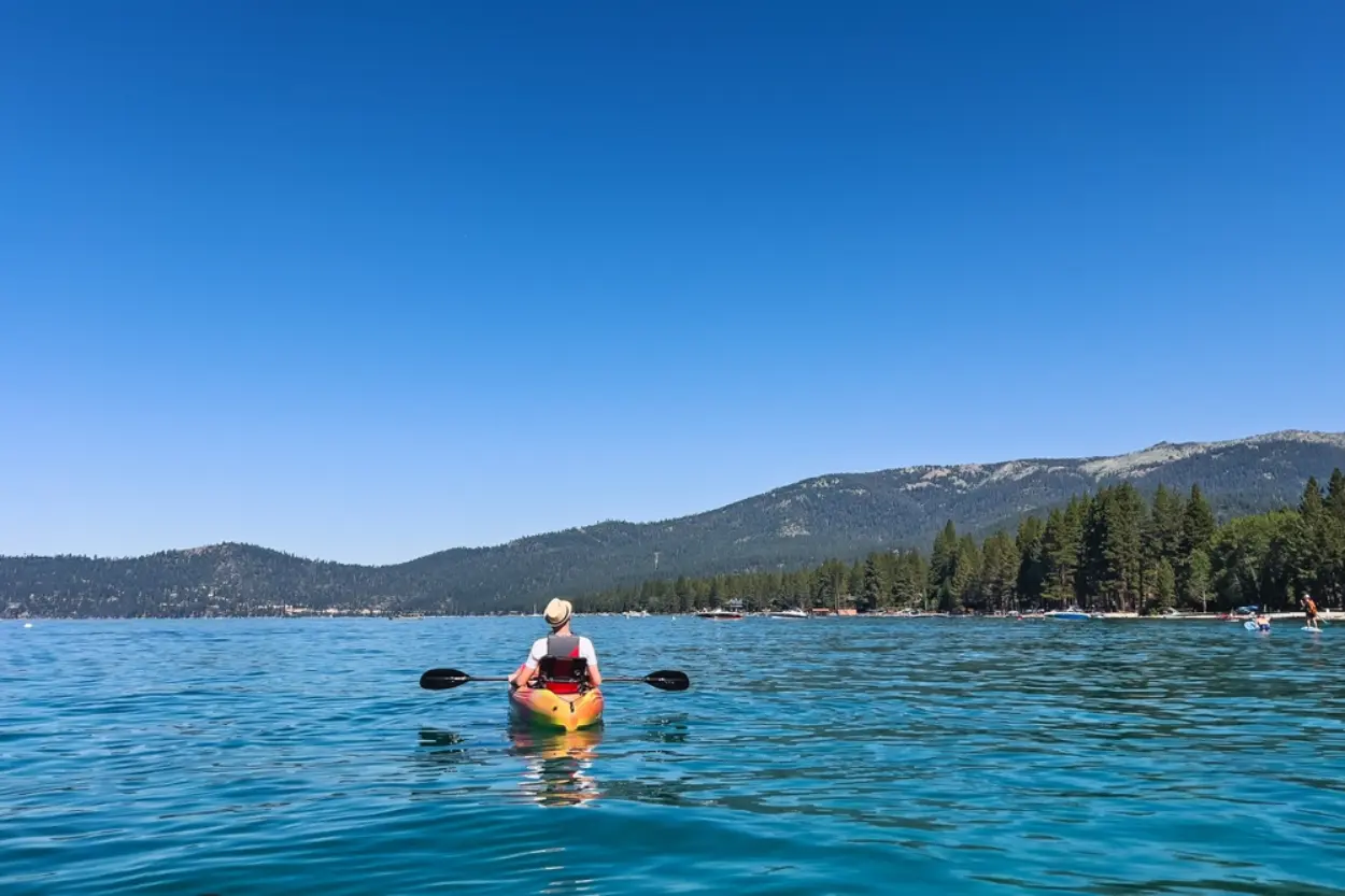 A solo kayaker on Lake Tahoe, enjoying the incredible view.